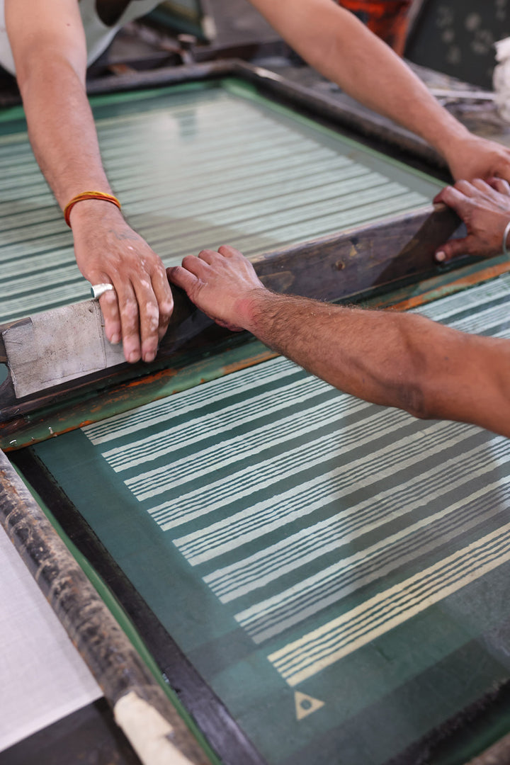 Person working with a screen printing press to create Kyra Mini Spearmint